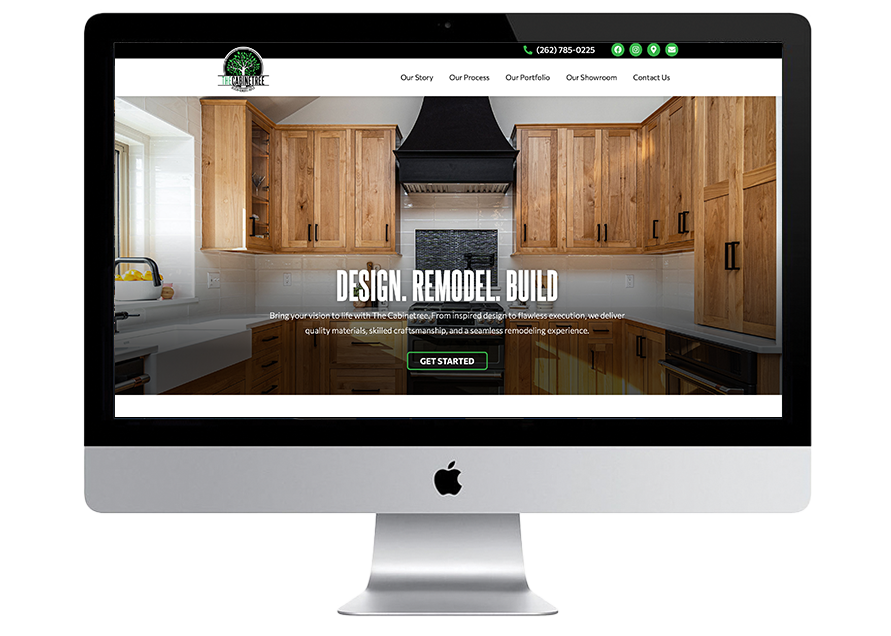 An iMac displays a website with a modern kitchen photo featuring wooden cabinets and a black range hood. The website header includes navigation links and a green call-to-action button labeled Get Started.