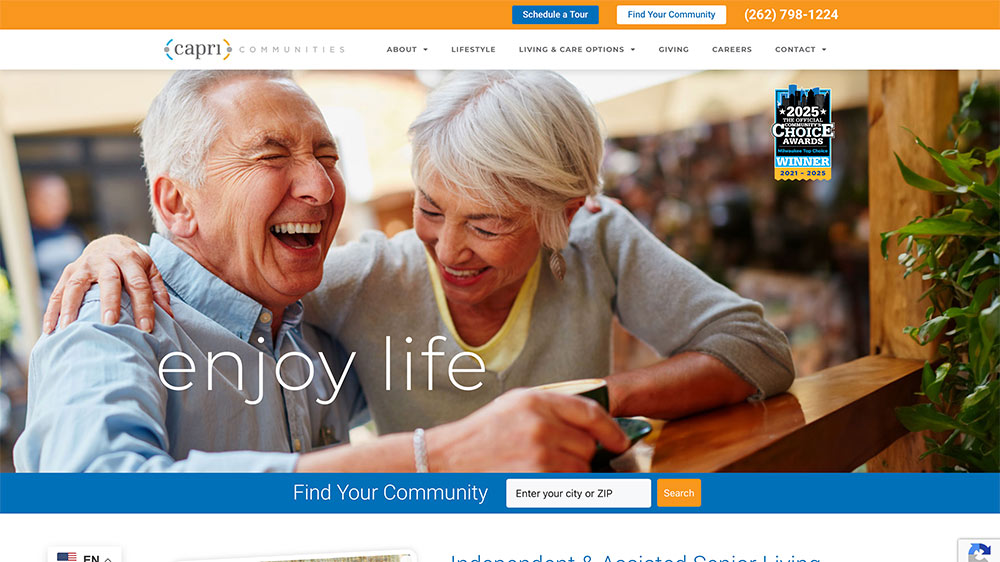 Two happy older adults smile and laugh together over coffee at a café, with the text enjoy life and a search bar for finding a senior living community displayed on the website.